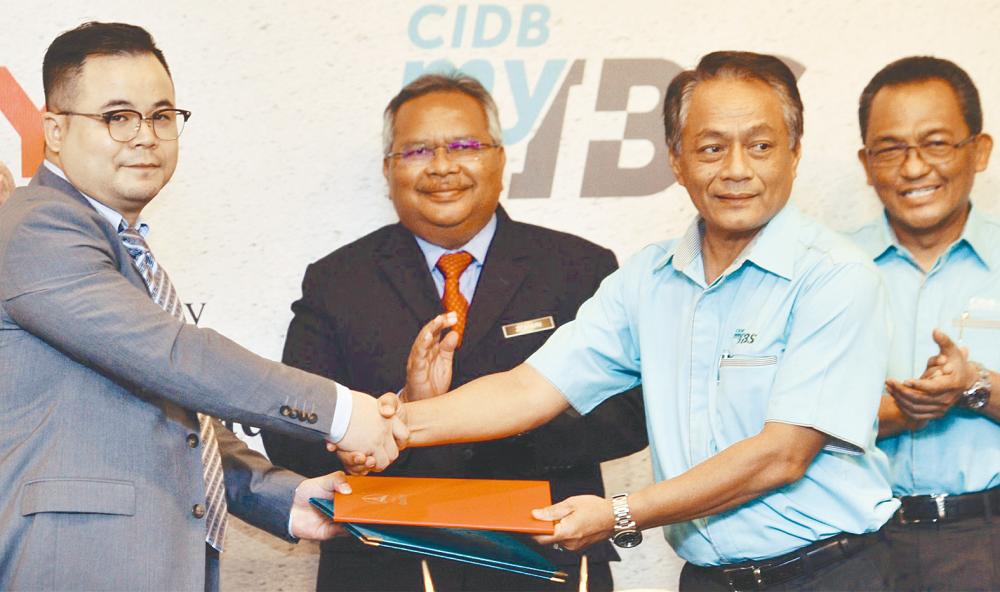Sany managing director Wang Zhenyi (far left) exchanging documents with CIDB IBS deputy chairman Datuk Ir Elias Ismail during the MoU signing ceremony yesterday. - Zulkifli Ersal/THESUN
