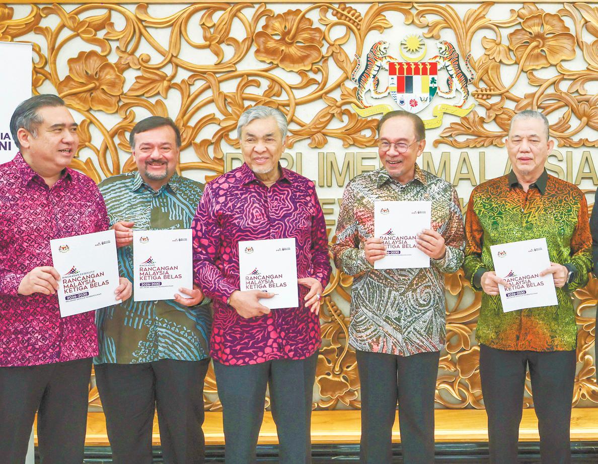 Anwar (second, right), Deputy Prime Ministers Datuk Seri Dr Ahmad Zahid Hamidi (third left) and Datuk Seri Fadillah Yusof (right), Transport Minister Anthony Loke (left) and Finance Minister II Datuk Seri Amir Hamzah Azizan displaying copies of the 13th Malaysia Plan. – Bernamapic
