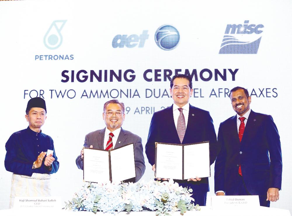Shamsul (second from left) and Zahid displaying the signed documents. They are flanked by Ahmad Adly (left) and Rajalingam.