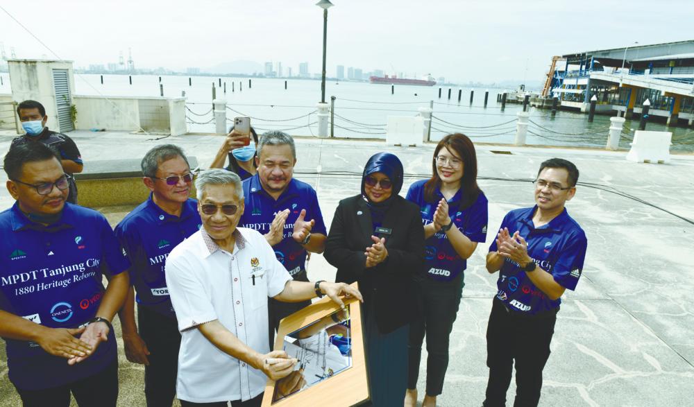 Mansor signing a plaque at the stone-laying ceremony for a desalination facility at Tanjung City Marina. Second from left is Nik Zamri and fourth from right is MPDT Capital chairman Datuk Roslee Chik. – Bernamapix