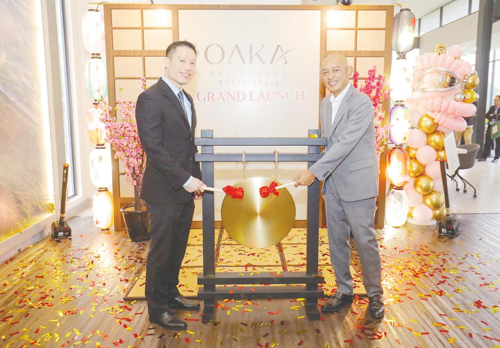 Berjaya Land group executive director Datuk Abdul Rahim Mohd Zin (right) and executive director Tan Tee Ming hitting the gong to launch OAKA Residences in Berjaya Property Gallery, Bukit Jalil. – ADIB RAWI YAHYA/THESUN