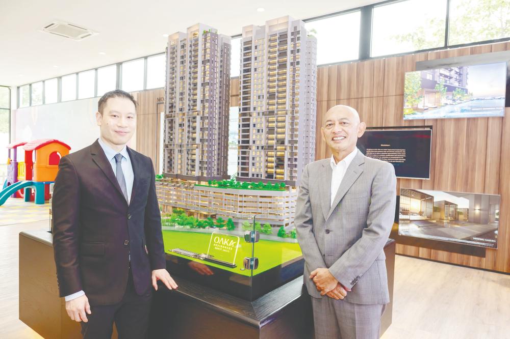 $!Abdul Rahim and Tan posing in front of a scale model of OAKA Residences. – BERJAYA HARTANAH PIC