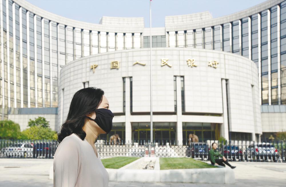 A woman walks past the People’s Bank of China building. The central bank will largely rely on a mix of liquidity policy tools to support the economy. – REUTERSPIX