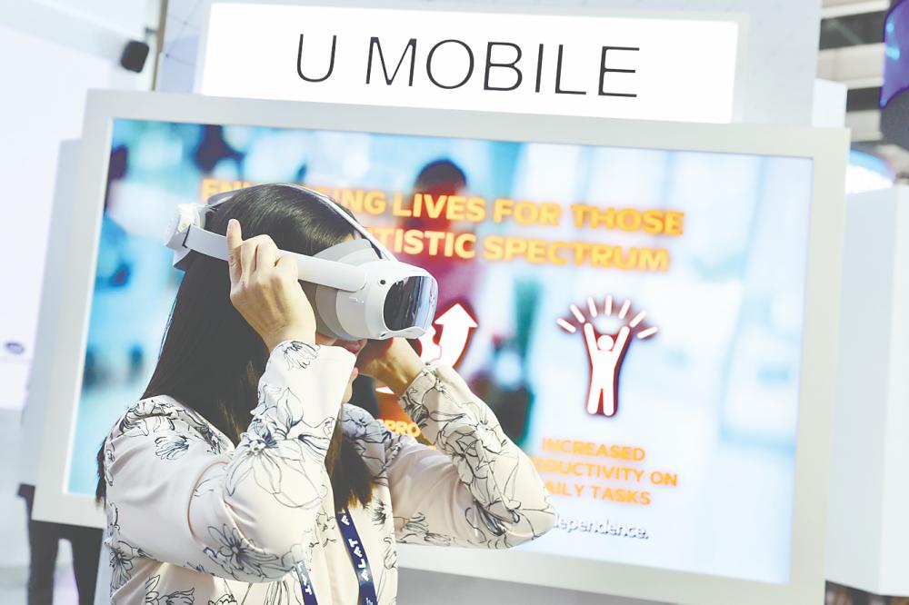 Teo trying out an exhibit during her visit to the Malaysia Pavilion after witnessing a memorandum of understanding exchange ceremony at the Mobile World Congress 2025 in Barcelona, Spain. – Bernamapic