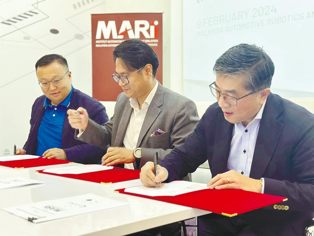From left: Li, Azrul Reza and Zhang at the signing ceremony.