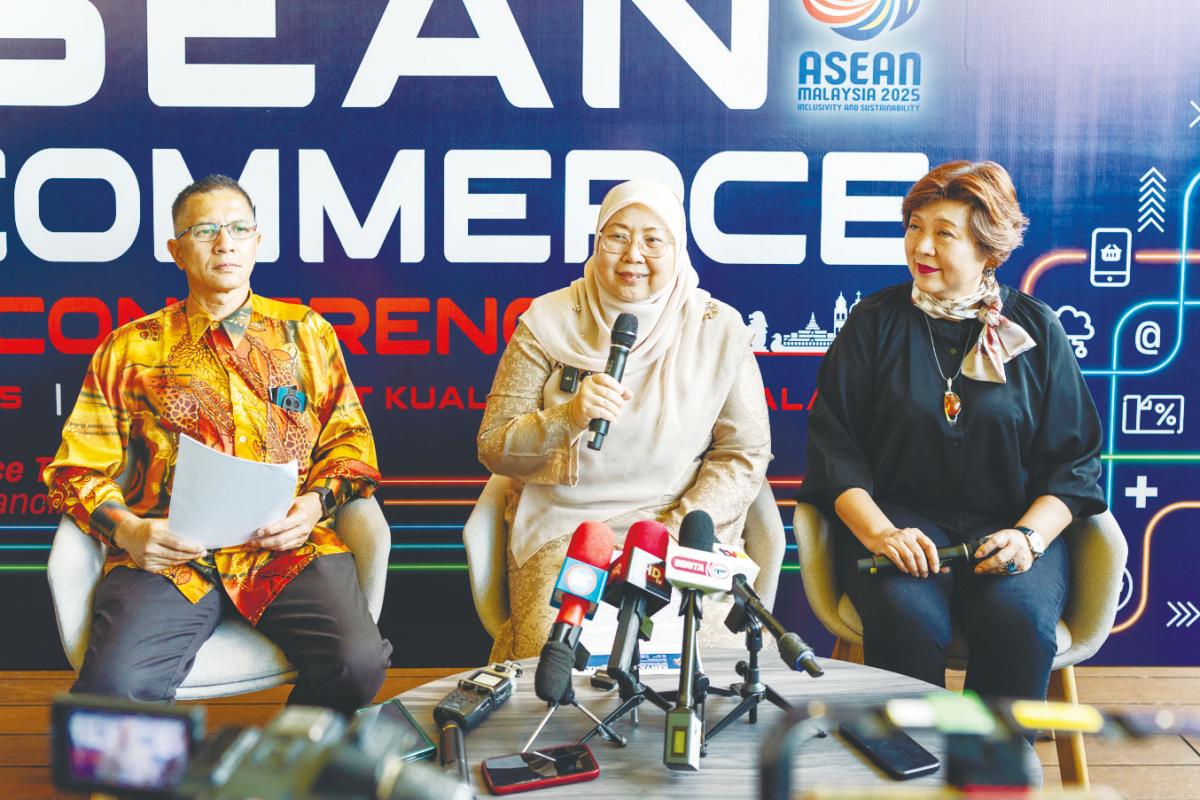Fuziah speaking at the soft launch of the inaugural Asean E-Commerce Conference 2025. Flanking her are Tee (right) and Domestic Trade and Cost of Living Ministry deputy secretary general (consumer empowerment and management) Datuk Amran Ahmad.