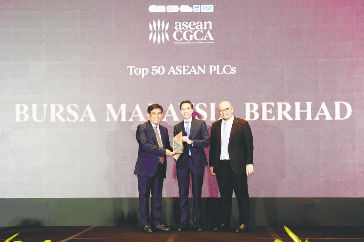 Fad’l (centre) receiving the award on behalf of Bursa Malaysia from Asean Capital Markets Forum working group on corporate governance and Philippines Securities and Exchange Commission chair Francisco Edralin Lim. On the right is Minority Shareholders Watch Group CEO Dr Ismet Yusoff.
