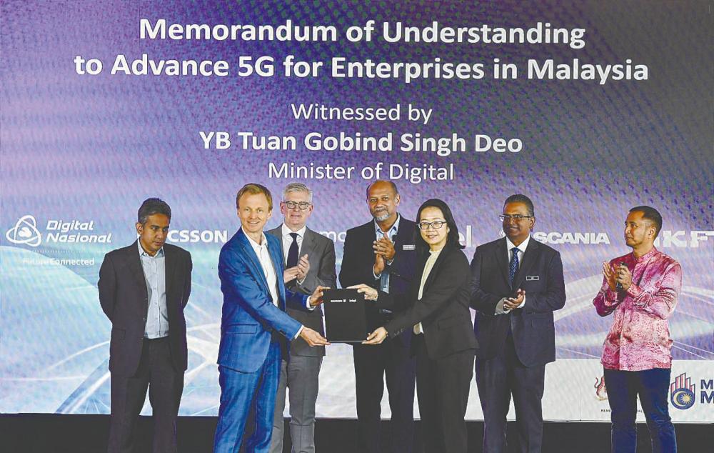 Gobind (centre) and Ekholm (third from left) witnessing the exchange of documents after the signing of a memorandum of understanding between DNB and Ericsson with enterprise partners at DNB's headquarters in Kuala Lumour. Also present are Ahmad Zaki (left) and DNB chief operating officer Nasution Mohamed (right).– Bernamapic