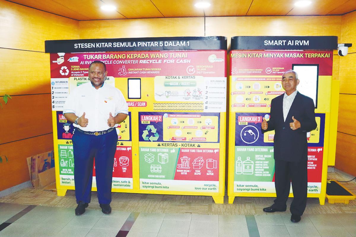 From left: Ramli and HMA Digital chairman Datuk Baharon Talib in front of the AI-powered Smart 5-in-1 Reverse Vending Machine.
