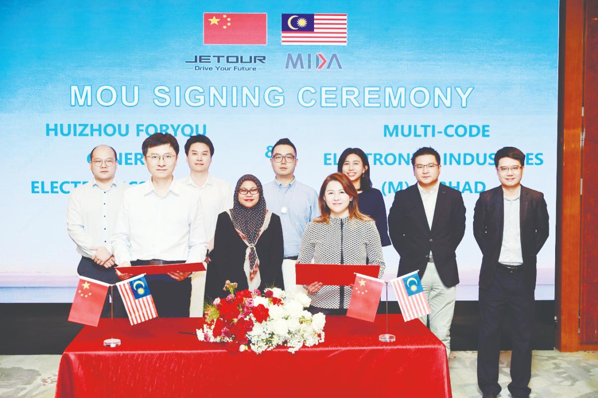 Front row: Adayo sales director Wei Song (left) and MCE Group executive director Anne Goh exchange MoU, witnessed by Mida Transportation Technology Division director Noor Suziyanti Saad (back row, third from left) and Mida Shanghai vice-consul (investment) Por Yee Yun (back row, fifth from left). Others pictured are representatives from Jetour, Adayo and MCE.