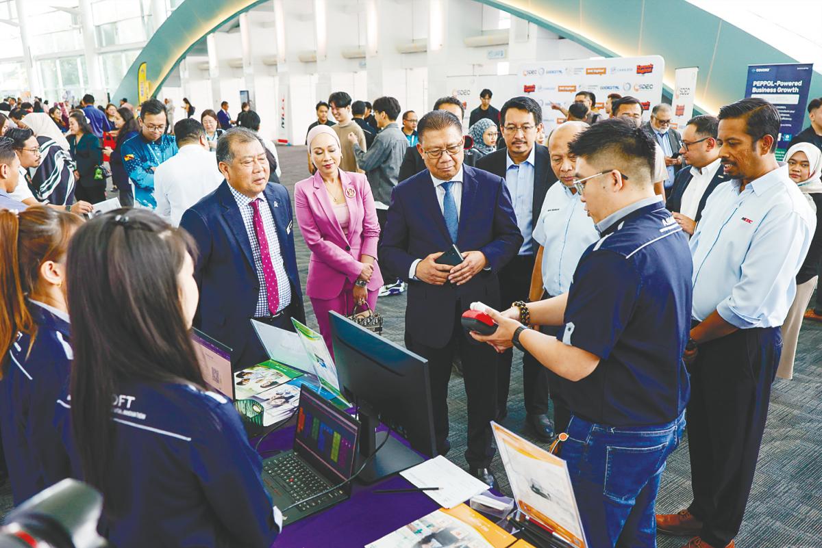 Julaihi, accompanied by Ugak and MDEC representatives, visiting exhibition booths showcasing digital solutions for MSMEs in conjunction with the MD Business Digitalisation Initiative launch in Kuching.