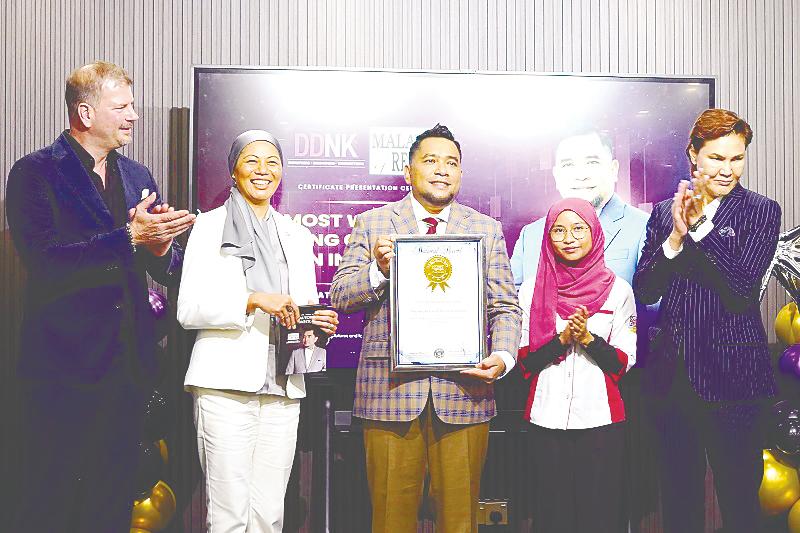 Nazri (centre) receiving the certificate of recognition as the ‘Most World Cup Trading Championships Won in a Year 2024’ from Malaysia Book of Records head of research Siti Norhanim Mohd Noh (second from right). Looking on are International Federation of Technical Analysts president Wieland Arlt (left), Malaysian Association of Technical Analysts deputy chairman Anisah Ozleen Othman (second from left) and DDNK Academy senior vice-president Datuk Jerry Rizal.