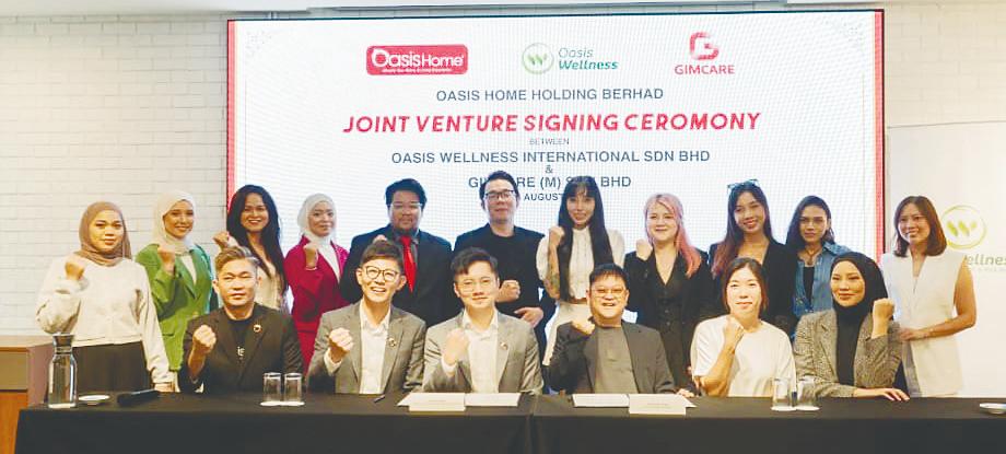 Teoh (seated, second from left) at the signing of the joint venture agreement between Oasis Wellness International and GIMCare (M).