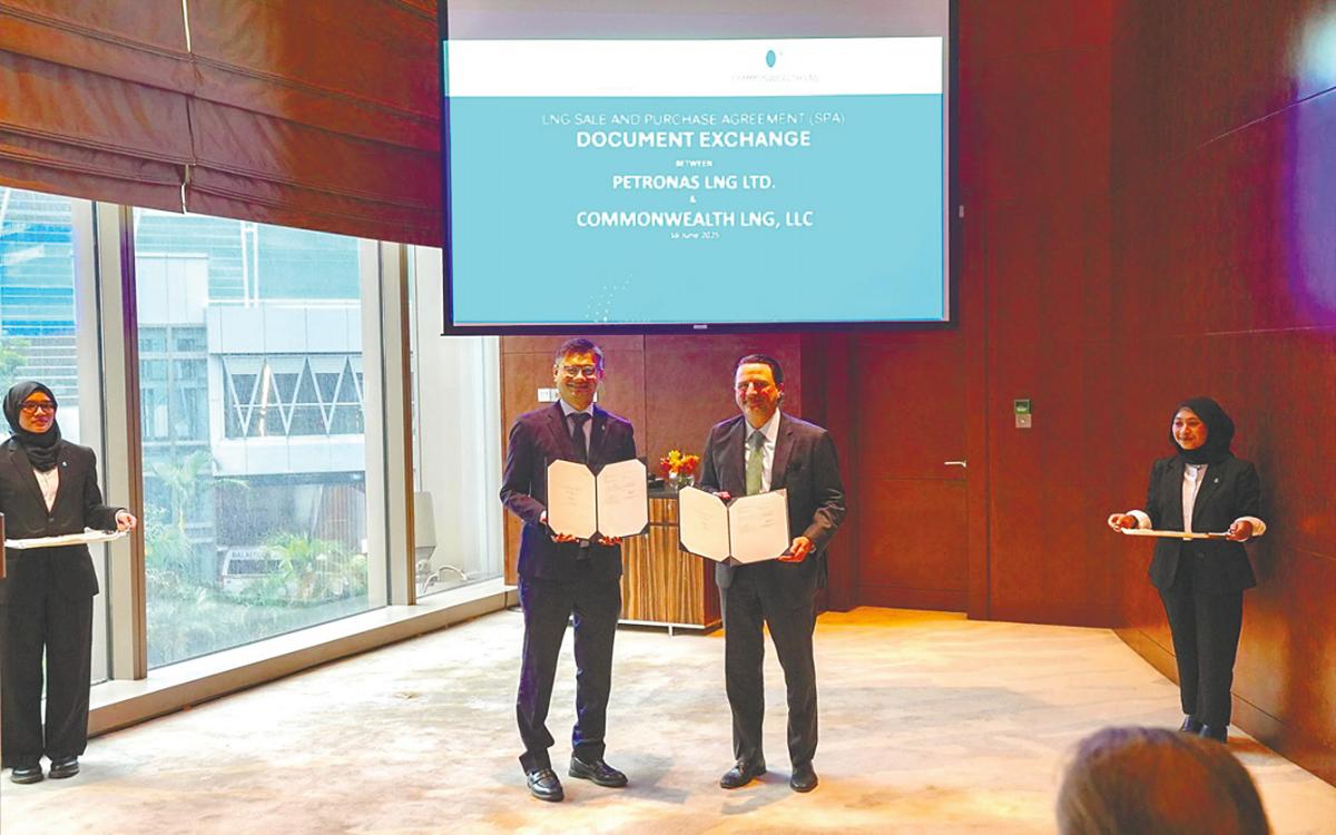 Ezran (left) and Farhad exchanging documents after the agreement signing ceremony on the sidelines of Energy Asia 2025.
