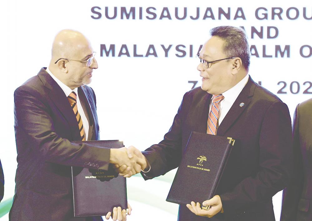 Ahmad Parveev (left) and Norazlam exchanging documents after signing the memorandum of agreement today. – Bernamapic