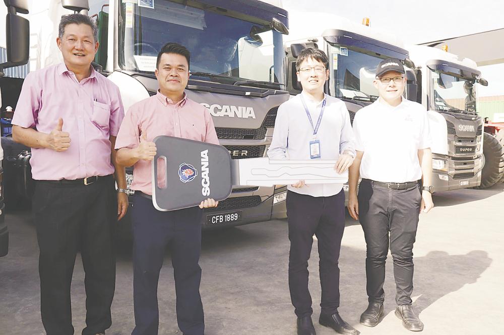 Yew (second from right) formally receiving the keys to the Scania Super trucks from Chin (second from left), signifying the continued collaboration between both companies. – Scania pic
