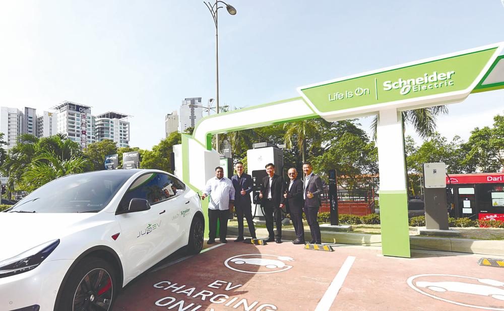 From feft: Bukit Gasing assemblyman Rajiv Rishyakaran, Quah, Wong, Tan and Schneider Electric Malaysia residential and general distribution VP vice-president Francis Heng at the site of the new EV charging station.