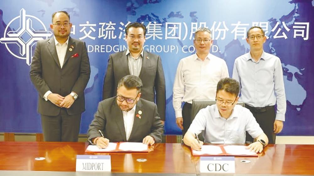 Signing the MoU are Midports Holdings executive director Datuk Wira Chuah Lim Leng (left) and CCCC Dredging vice-president Huang Daojin. Standing, from left, are Tanco Builders Sdn Bhd managing director Eugene Choo Ewe Chuen, Tan, Liu and CCCC Dredging international business division executive general manager Li Feng.