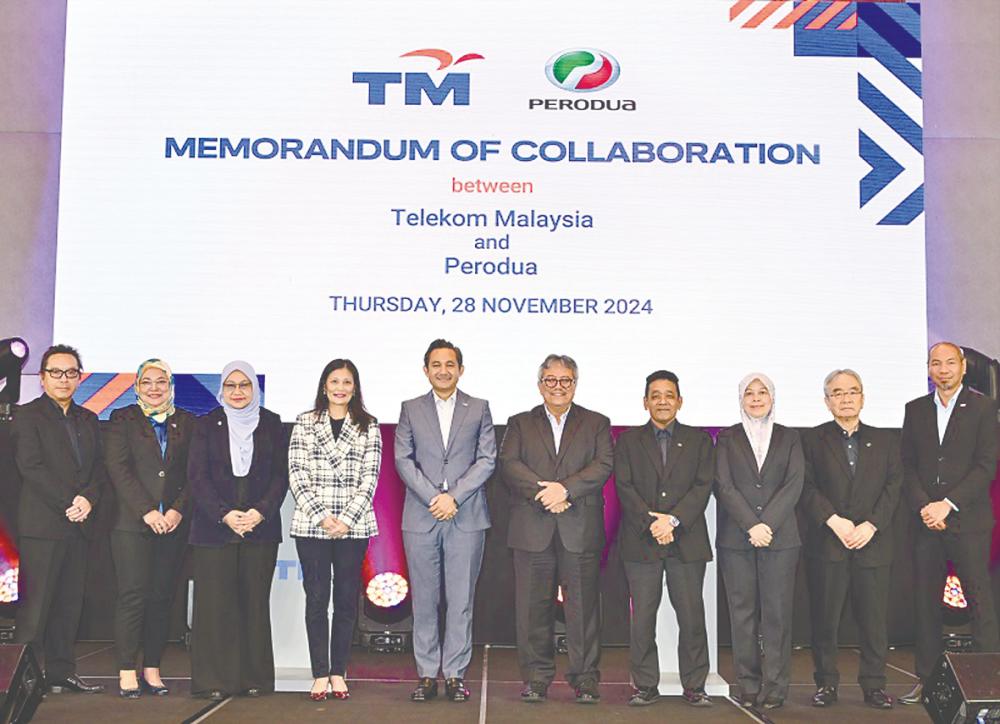 Amar Huzaimi and Zainal Abidin (fifth and six from left, respectively) with senior management of TM and Perodua at the memorandum of collaboration exchange ceremony.