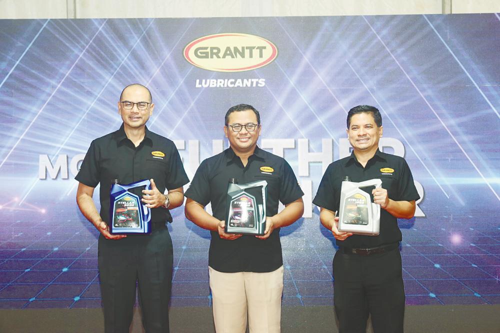 Amirudin (centre) with UMW Holdings officer-in-charge Megat Shahrul Azmir (left) and Anas Nasrun displaying the new Grantt packaging.