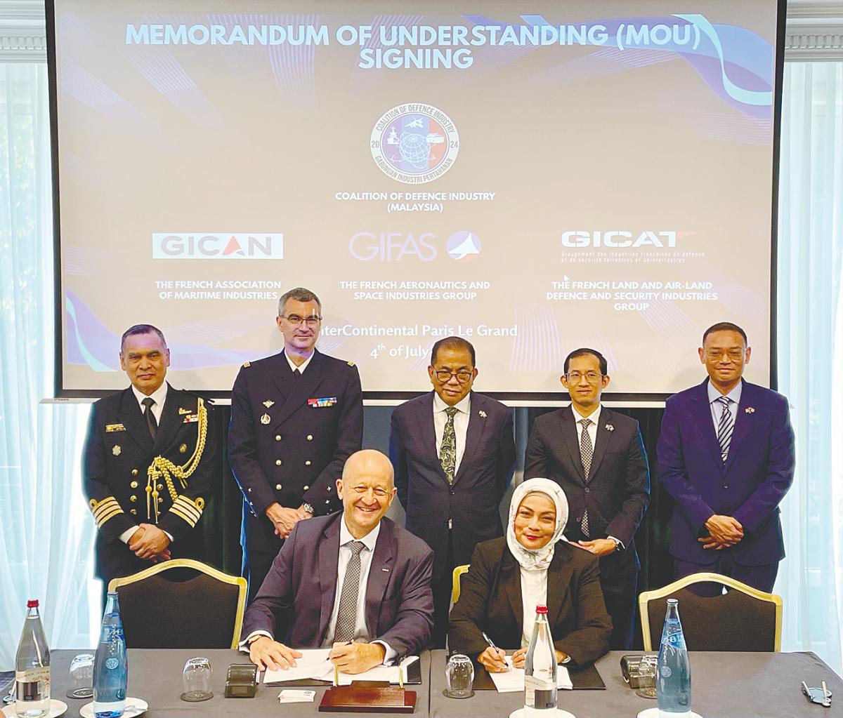 Dubrule (seated, left) and Nonee Ashirin at the signing of the MoU.
