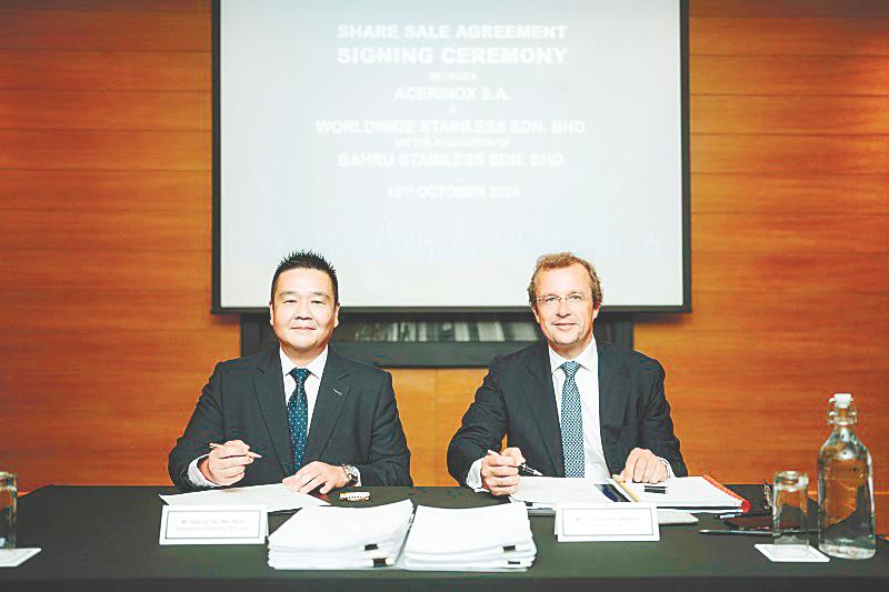 Tan (left) and Acerinox S.A. general counsel &amp; board secretary Luis Gimeno at the signing ceremony.