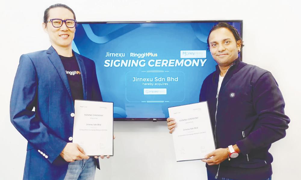 Yuen (left) and Rohith at the signing of an agreement between Jirnexu and MoneyHero. – MoneyHero website pic