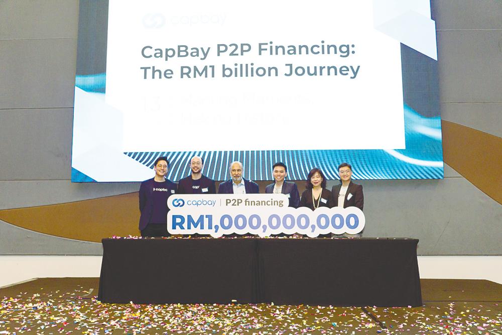 From left: CapBay directors Darrel Ang, Dion Tan and Mohd Mokhtar Shariff, CEO Ang Xing Xian, directors Jasmine Lau and Edwin Tan marking the RM1 billion P2P financing milestone.