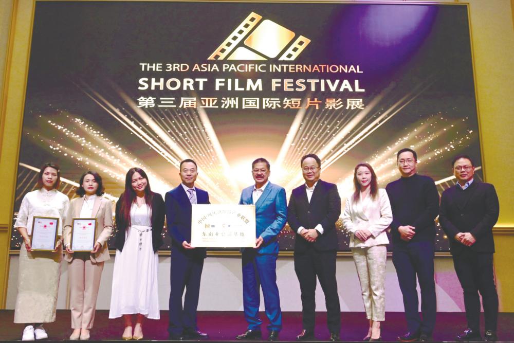 China Fengqing Dianhong Tea Industry Alliance president Zhang Guijing (centre, left) presenting a plaque to NCT Group executive director Datuk Joe Yap Fook Choy (centre, right) at the unveiling ceremony.