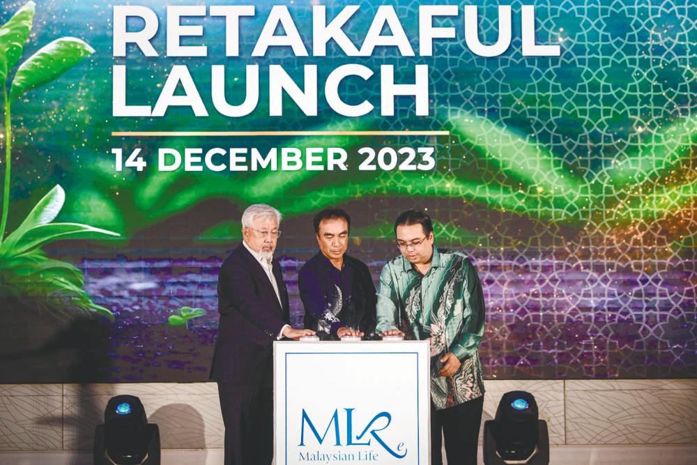 Adnan Zaylani (centre), MLRe chairman and independent director Datuk Kamaruddin Taib (left) and Cheah at the launch. – Bernamapic