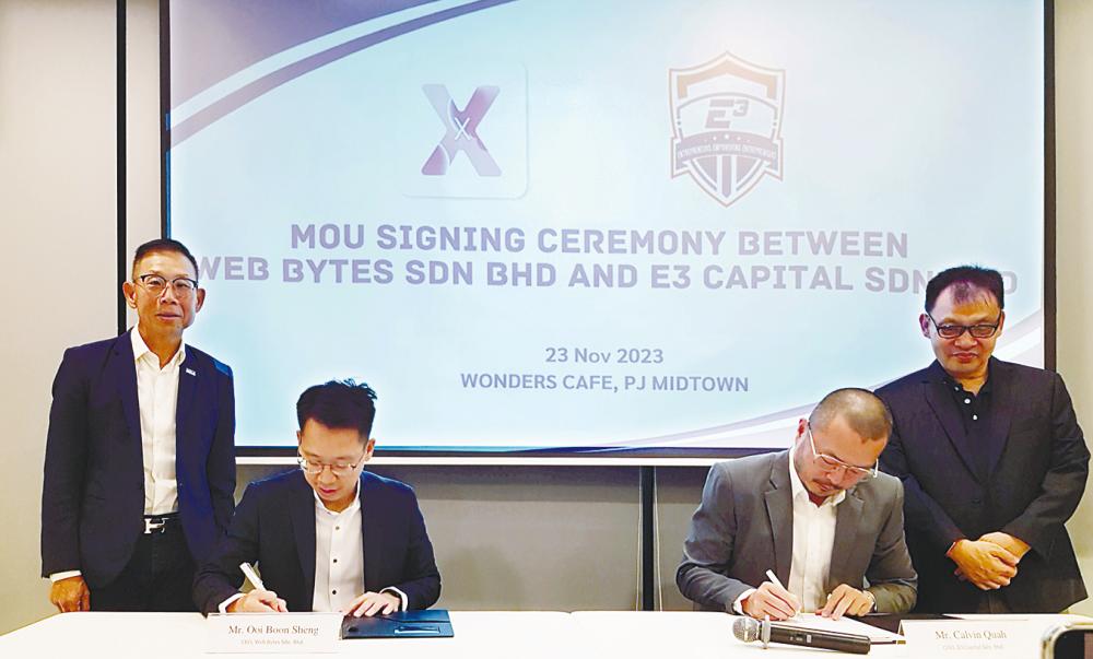 Ooi (left) and E3 Capital COO Calvin Quah signing the MoU, witnessed by Phua (left) and Wong.