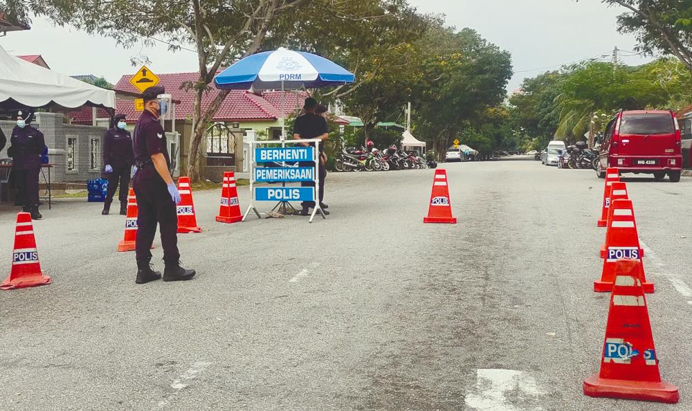 $!KEEPING WATCH ... Police and military personnel manning a roadblock near Batu Muda Tambahan, Sentul in Kuala Lumpur, which was placed under an enhanced movement control order yesterday. – SYED DANIAL SYED AZAHAR/THESUN