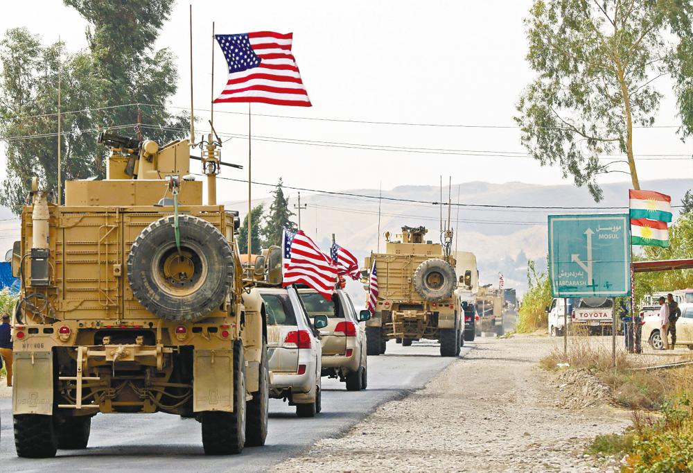 A convoy of US military vehicles arrives near the Iraqi Kurdish town of Bardarash in the Dohuk governorate after withdrawing from northern Syria on Monday. – AFPpix