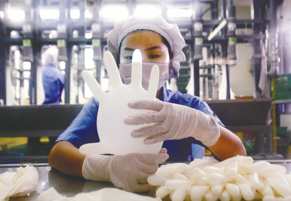 A worker testing a glove at a Top Glove factory. – REUTERSPIX