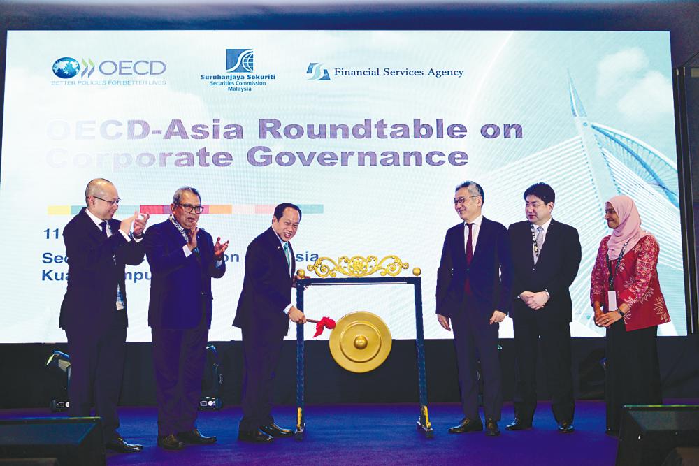 Awang Adek (second from left) and Ahmad Maslan (hitting the gong) at the launch.