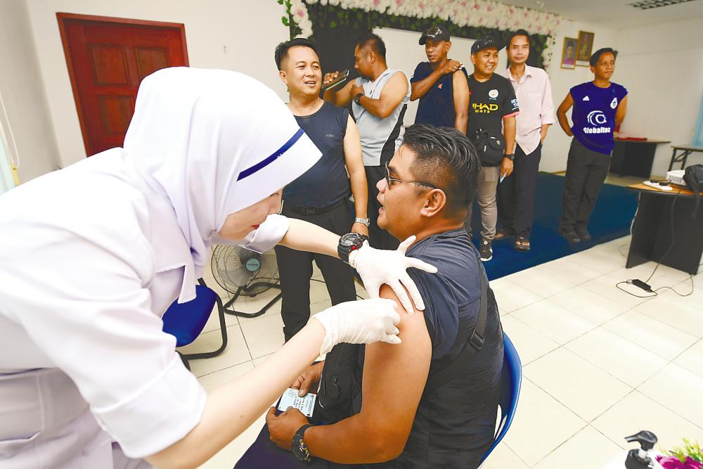 A National Security Council employee gets a flu shot at Sibuga Detention Centre in Sandakan on Oct 18. – Bernamapix