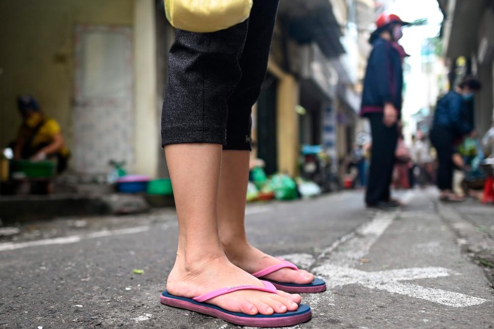 Residents practise social distancing at a wet market in Hanoi. – AFPpix