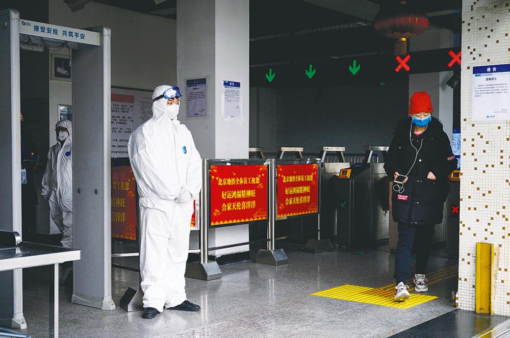 A security personnel in protective gear mans the entrance of a subway station in Beijing on Tuesday. – AFPpix