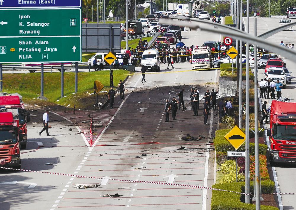 Police and rescue personnel at the site of the crash yesterday. – ADIB RAWI YAHYA/THESUN