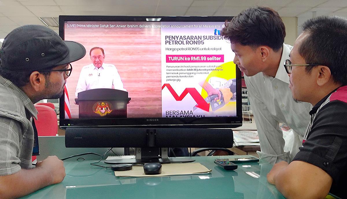 A group of man watches televisions as Malaysian Prime Minister Anwar Ibrahim addresses the nation during a live telecast. - SYED AZAHAR SYED OSMAN THESUN