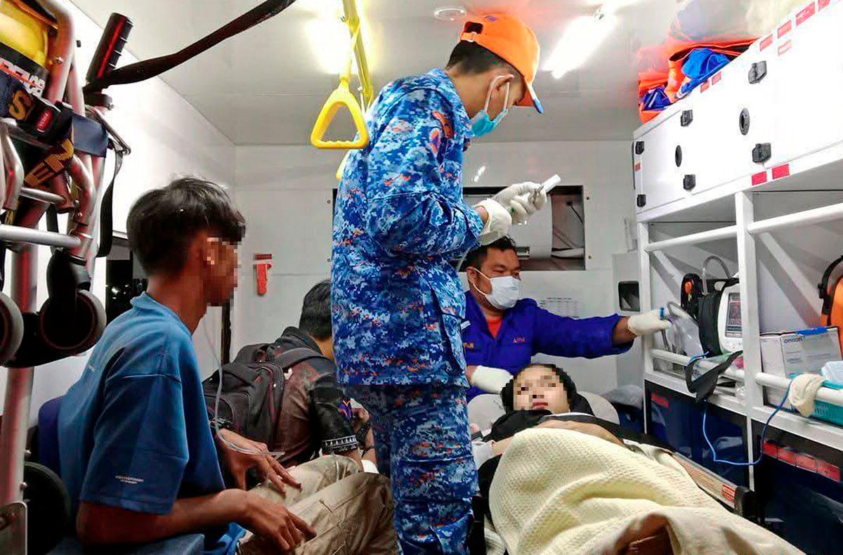 Injured victims of the crash receiving emergency treatment inside a Civil Defence Force ambulance following the collision along the East-West Highway near Banun, Gerik which claimed the lives of 15 Upsi students. – Pic courtesy of Fire and Rescue Department
