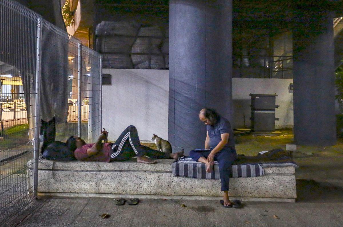 Homeless people who seek shelter under a bridge near the Pasar Seni LRT Station are among those who received packets of nasi bungkus. For Abbe (inset), the motivation comes from faith. – ADAM AMIR HAMZAH THESUN