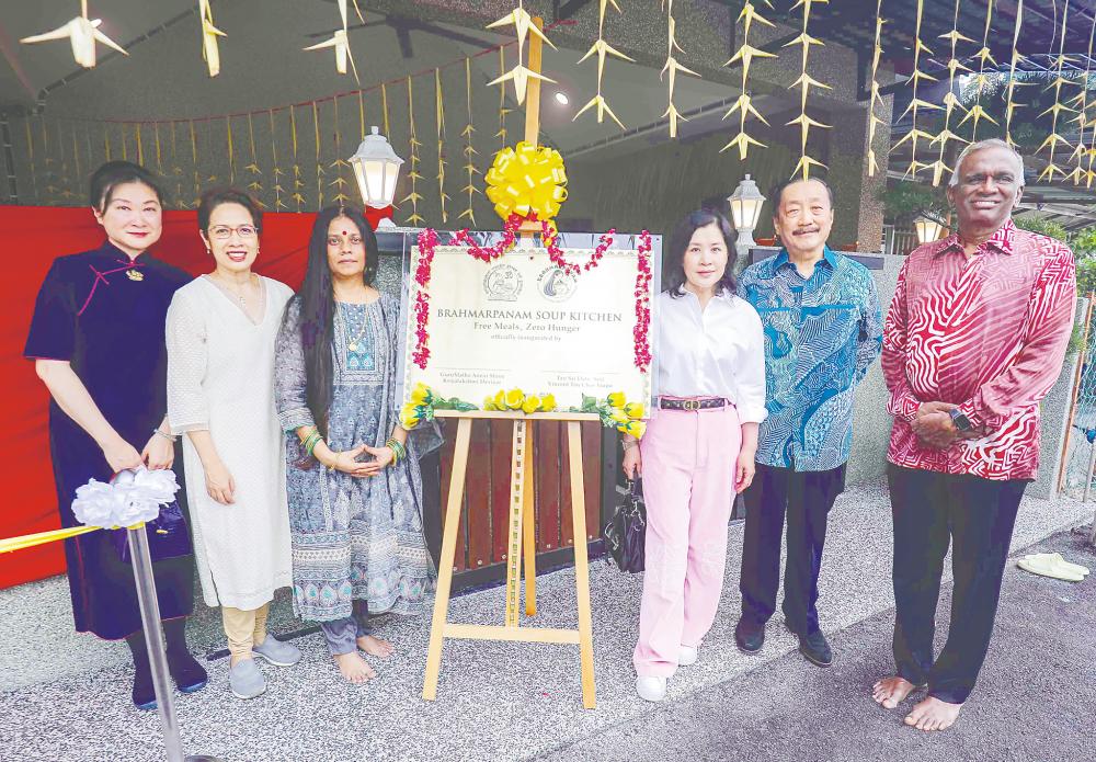 Tan, his wife Esther (third, right) and GuruMatha (third, left) at the opening of the soup kitchen. – Adib Rawi Yahya/THESUN