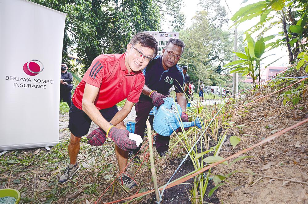 Tan planting trees with GEC’s River Care Programme Manager Dr Kalithasan Kailasam in Gombak on Sunday. – PICTURE COURTESY OF BERJAYA SOMPO INSURANCE BERHAD