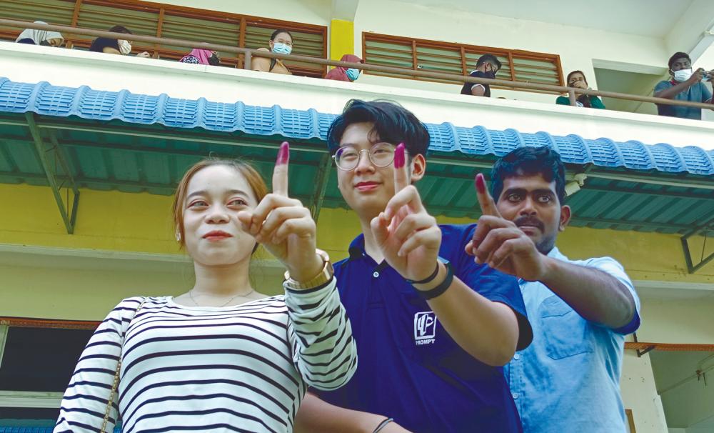 Young voters Nor Zulaikha Ahmad Sharil, 19, Tang Yan Shu, 19 and Agelan Govindarajoo, 25, showing their stained fingers after casting their ballots in Penang last Saturday. – MASRY CHE ANI/THESUN