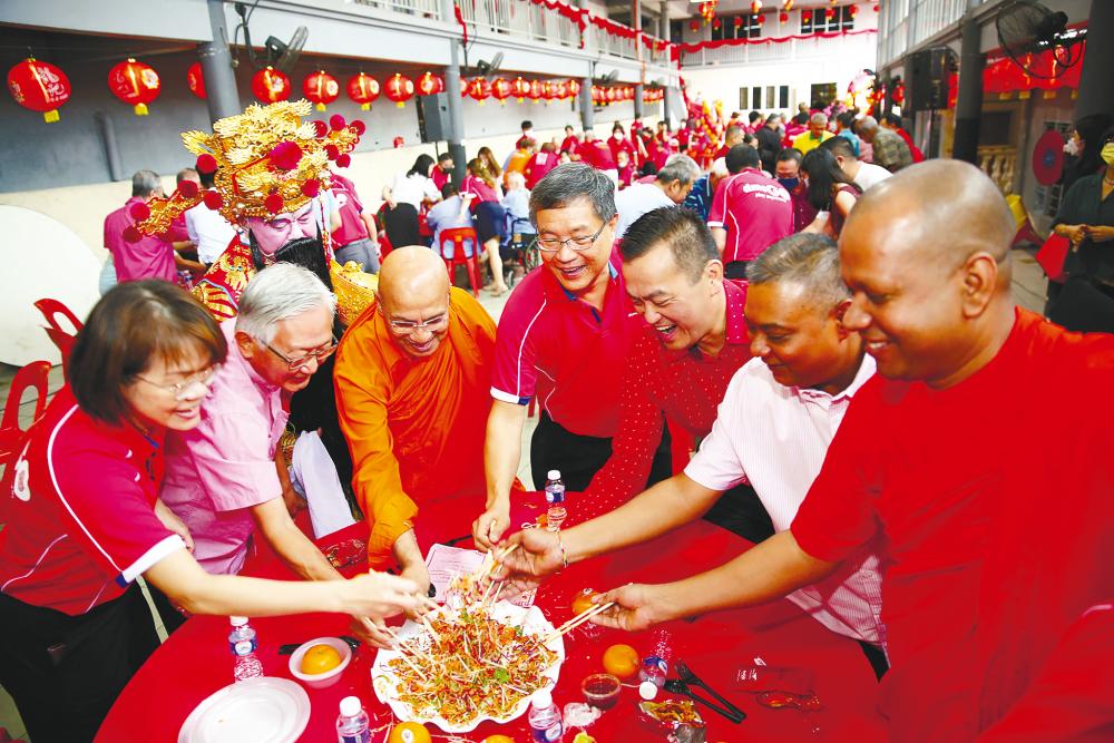 Guests at a recent charity event held in conjunction with Chinese New Year tossing ‘Yee Sang’.