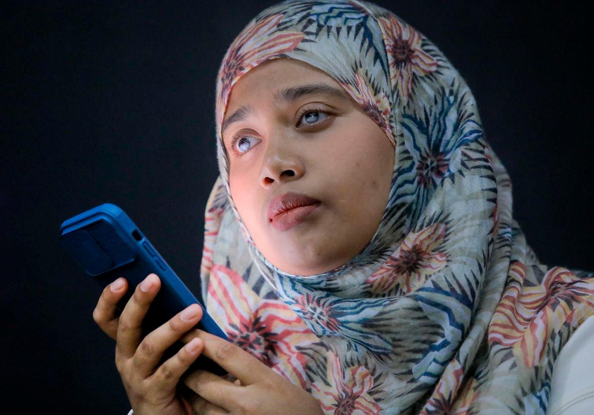 Sharifah Nur Jahan Syed Jakirul Alam, who is blind, using a voice-prompt feature on her smartphone during a separate interview with theSun. – ADIB RAWI YAHYA/THESUN
