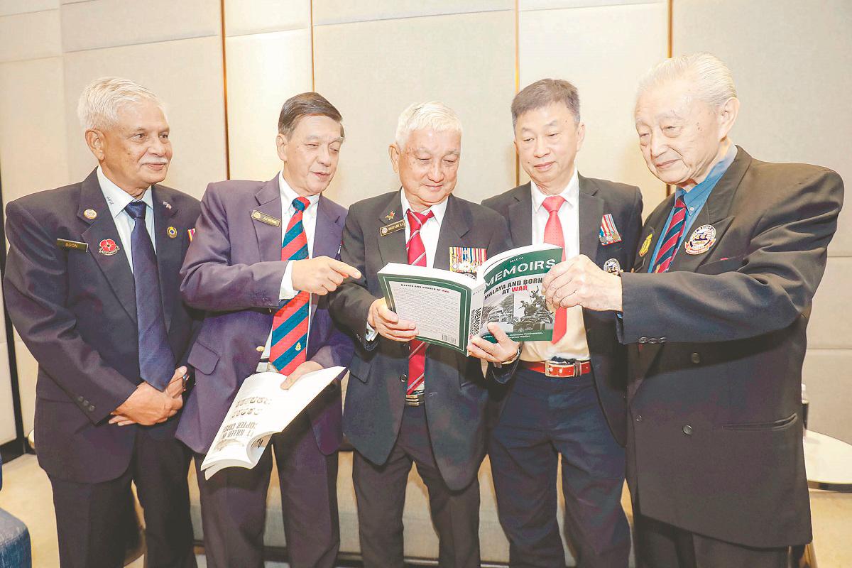 From second left: Wong, Lee and Liew browsing through Memoirs 1 and 2. – ADIB RAWI YAHYA /THESUN