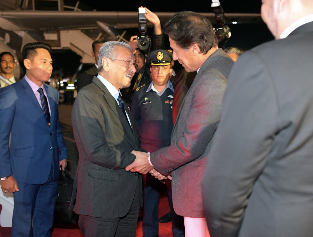 Prime Minister Tun Dr Mahathir greets his Pakistan counterpart Imran Khan when he arrived at Pakistan Air Force Base in Nur Khan, Rawalpindi in conjunction with his three-day official visit to the country, on March 22, 2019. — Bernama
