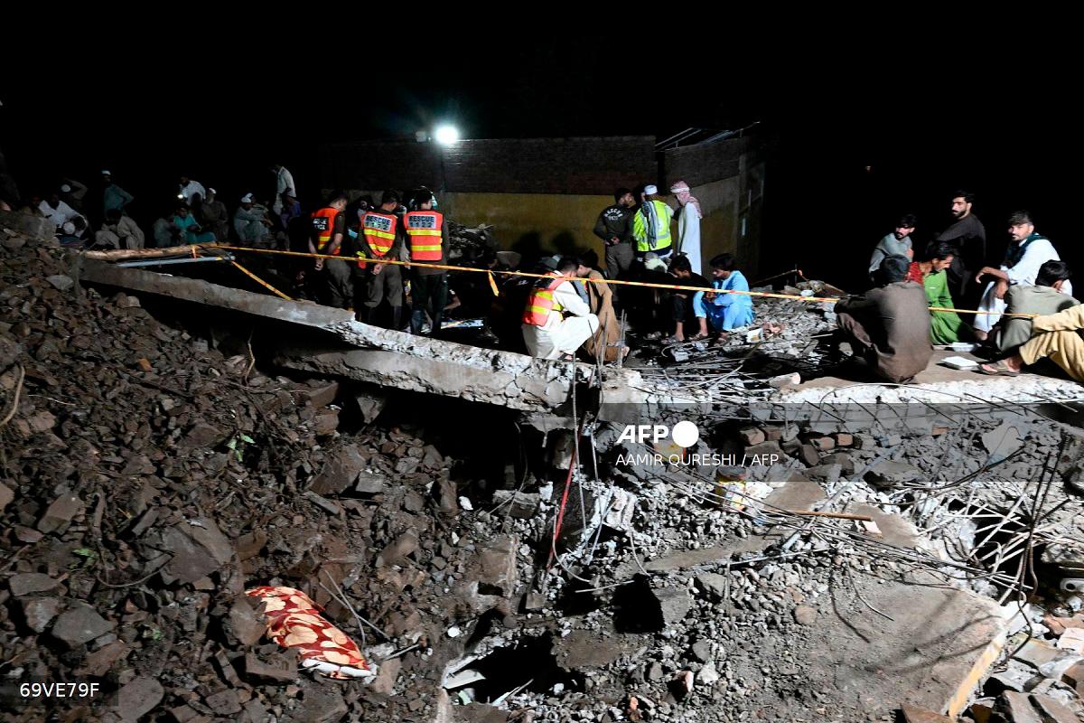 Rescue workers and residents search for victims in the debris of collapsed houses after a cloudburst in Dolari village, Swabi district, in northern Pakistan's mountainous Khyber Pakhtunkhwa province, on August 18, 2025. - Aamir QURESHI / AFP